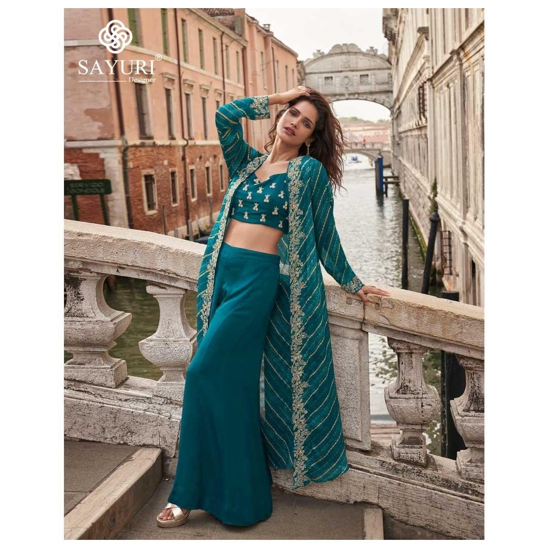 Make a bold festive statement with this trendy festive shrug set, crafted in premium real Chinon Silk & Viscose Jacquard Silk. Designed with front & back heavy embroidery, hand-embellished mirror work blouse, and a stylish plazzo, this outfit delivers a complete luxury ethnic look ✨💃